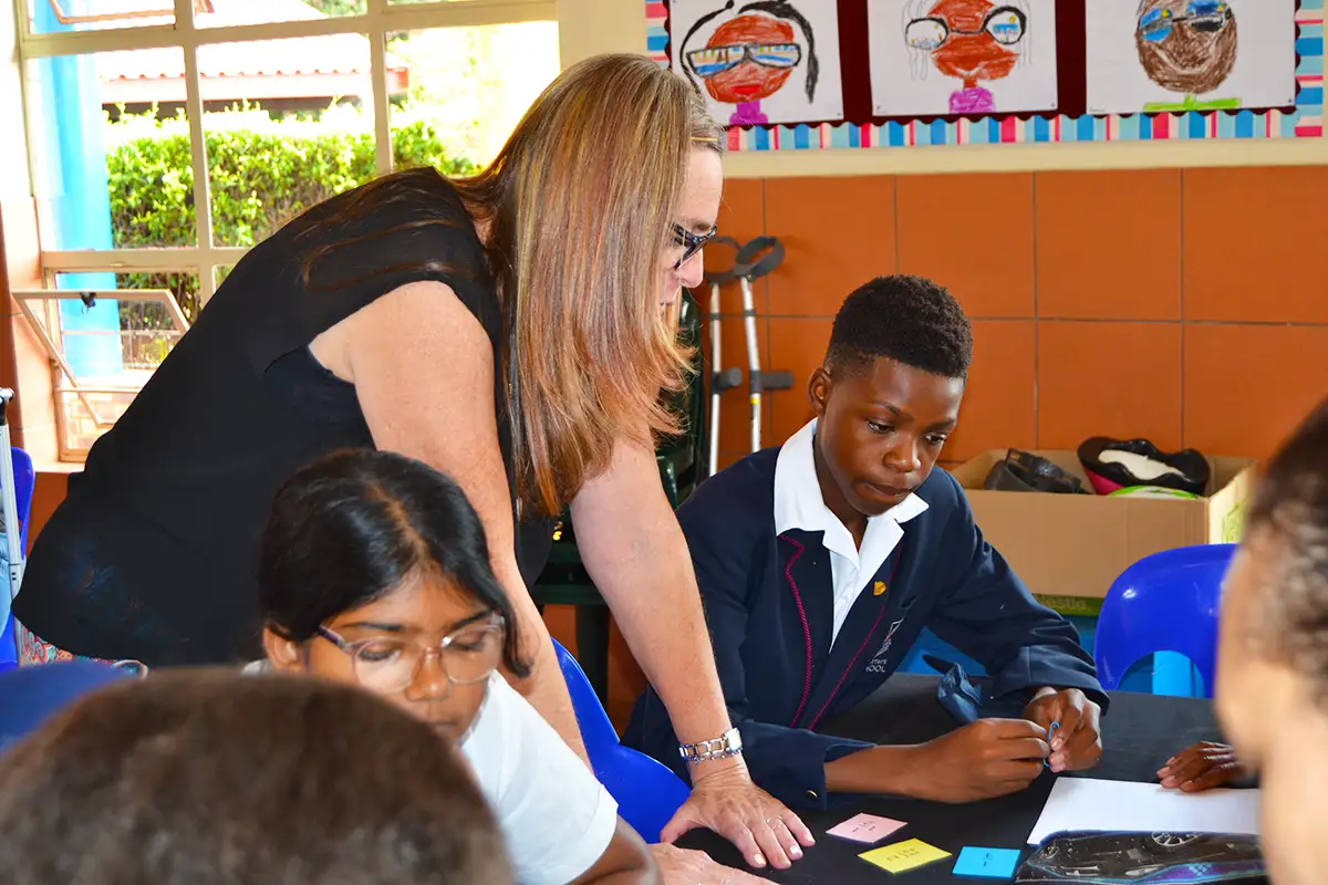 Teacher assisting a student with class work