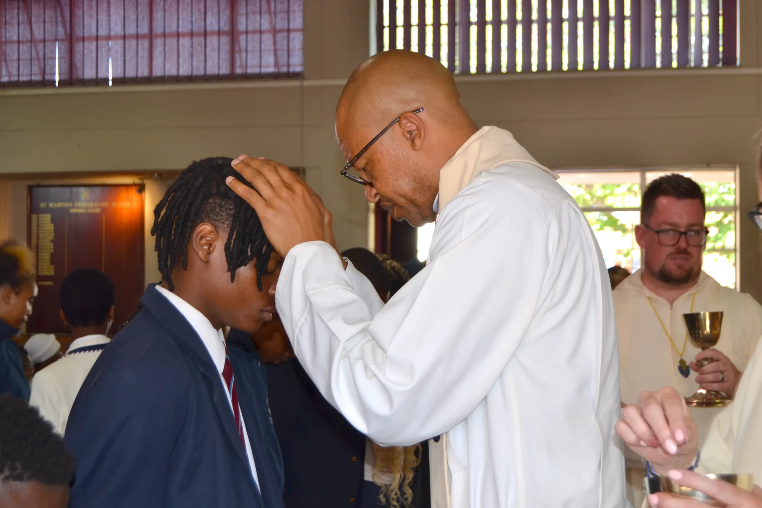 Pastor blessing a student with a prayer